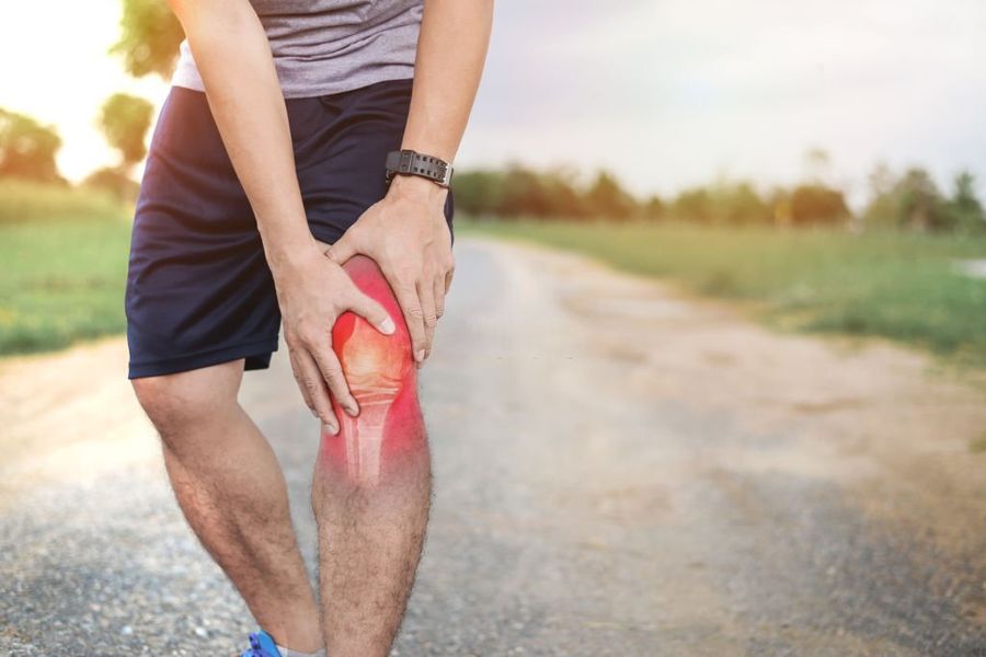 Physiotherapist assessing a client&rsquo;s knee during an in-home orthopaedic appointment